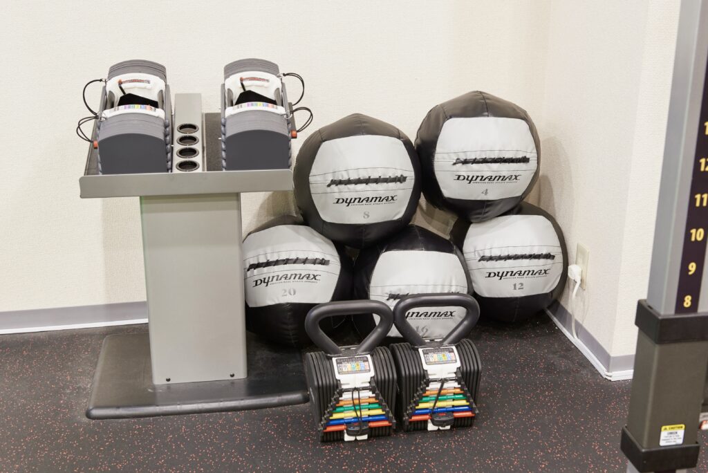 ダンベルとメディシンボールが並ぶDisport Worldの器具