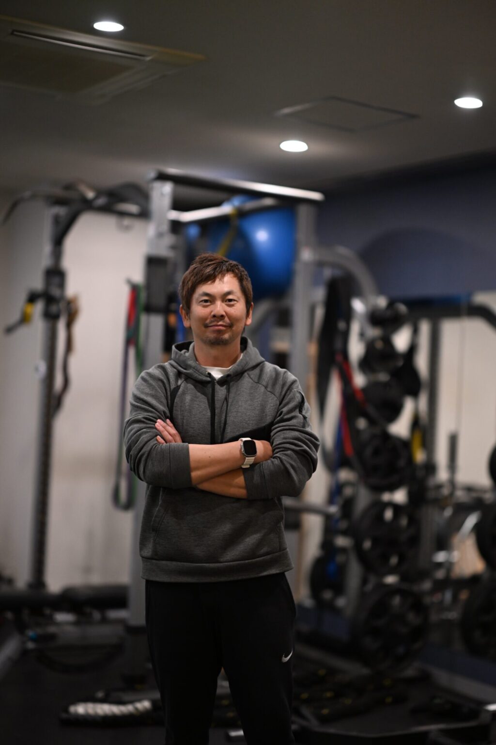 Disport World代表トレーナー 岡本隼人。六本木の店舗内、ラックの前で