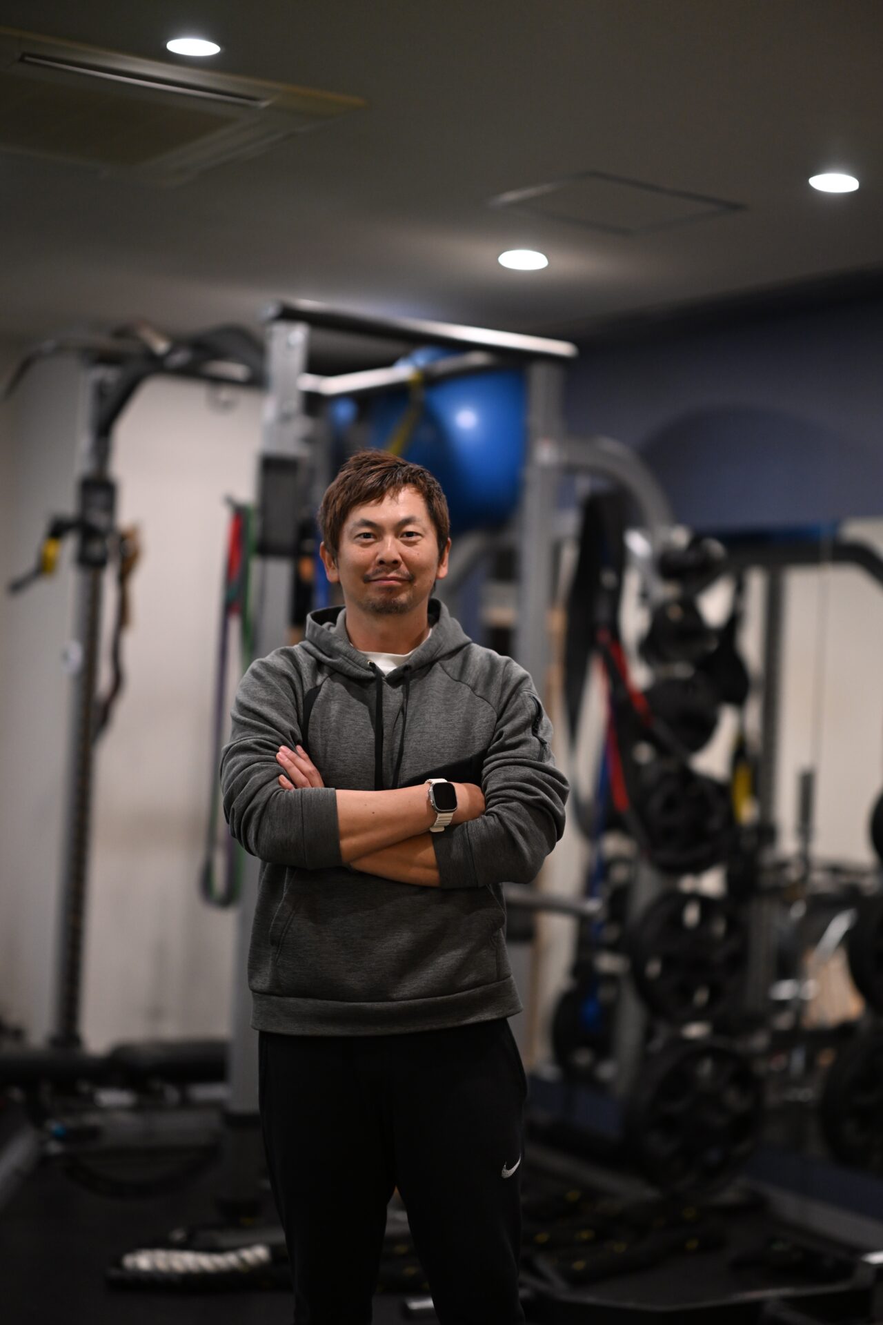 Disport World代表トレーナー 岡本隼人。六本木の店舗内、ラックの前で